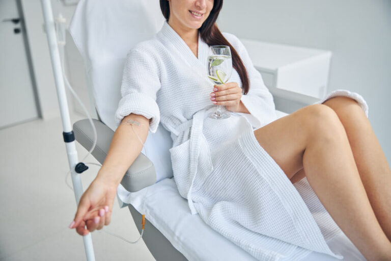 A woman smiling during an IV vitamin infusion therapy for vitamin and fast nutrient absorption 1 768x512